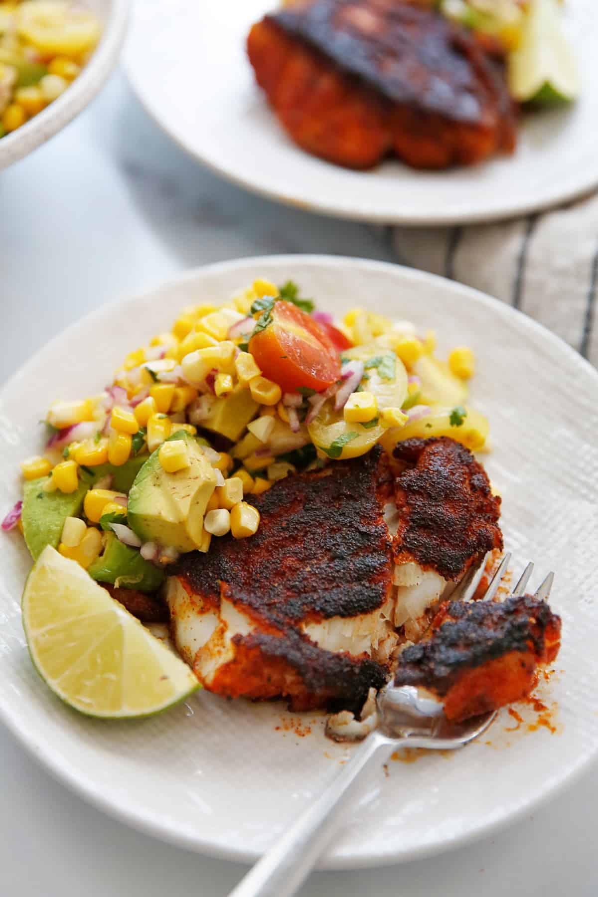 Corn salsa with avocado plated with fish