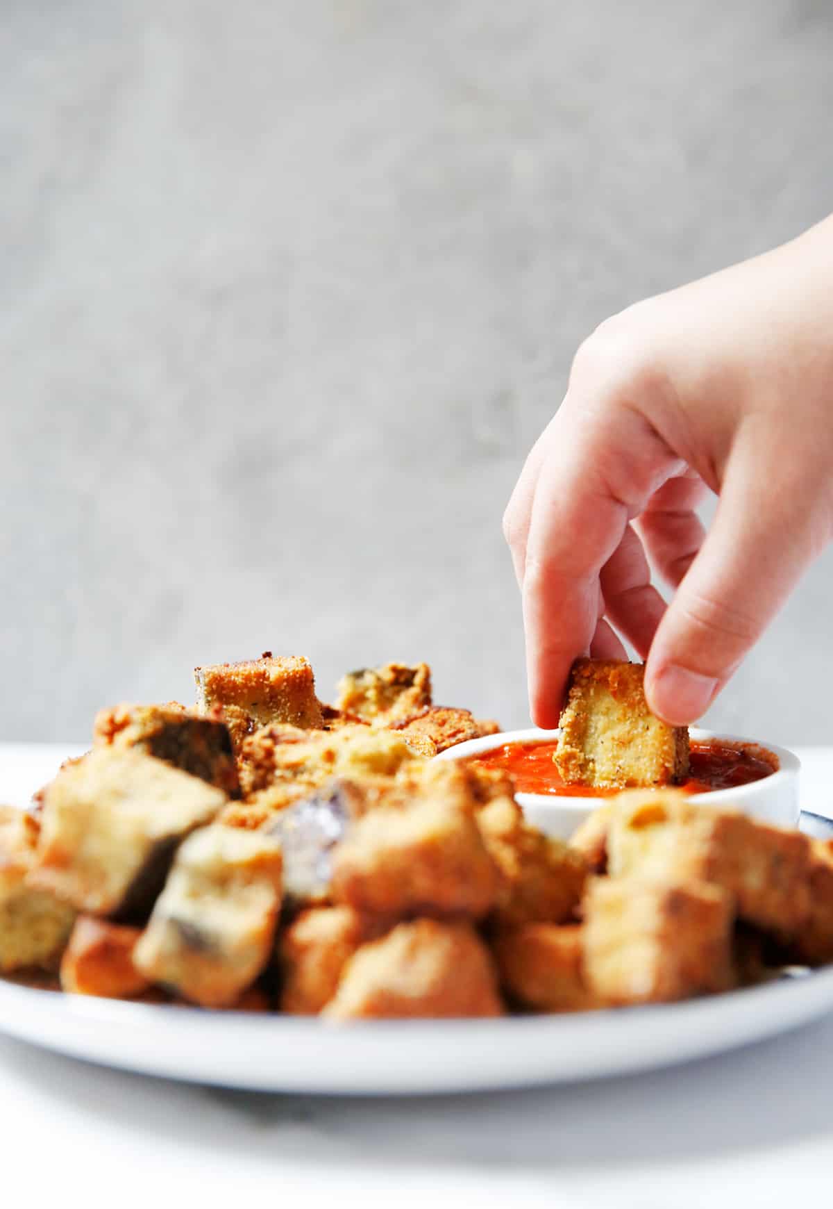 dipping eggplant Parm into marinara sauce