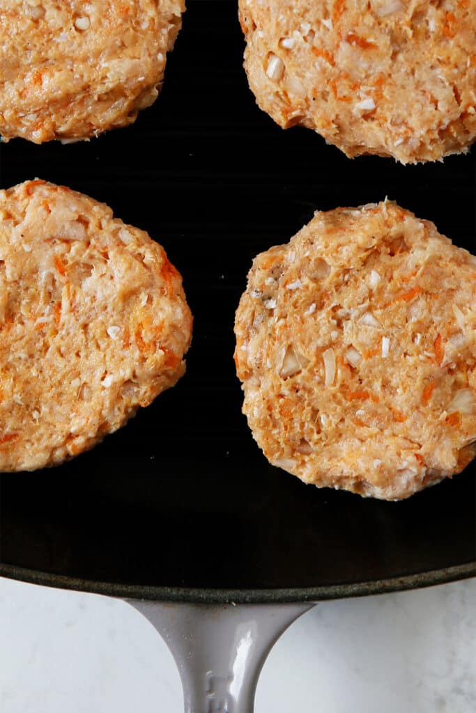 Chicken burgers on a grill pan.