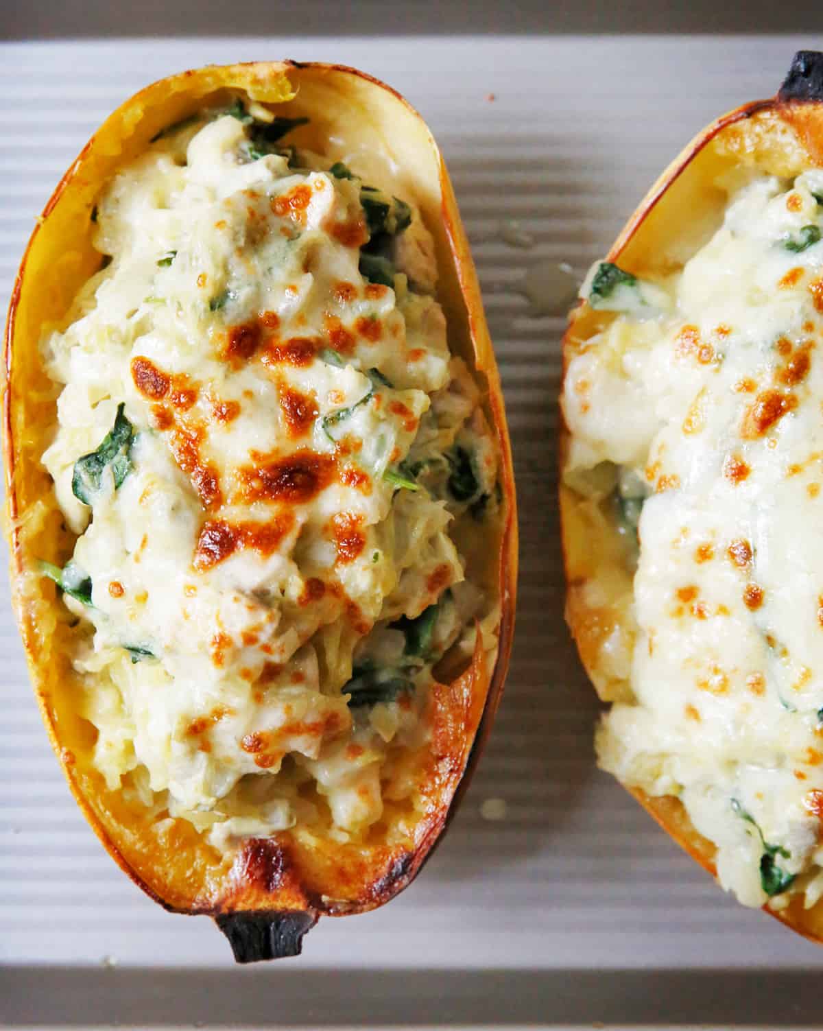 spinach artichoke stuffed spaghetti squash on a baking sheet