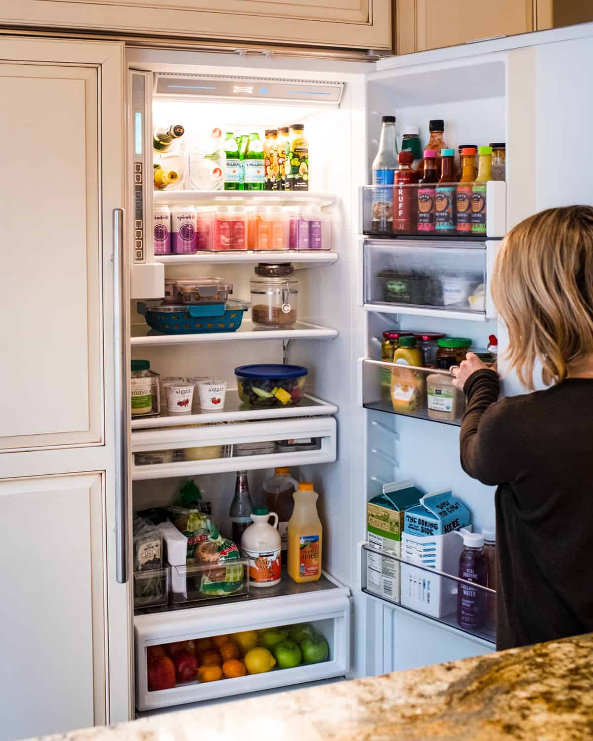 A neat and clean refrigerator with stored leftovers.