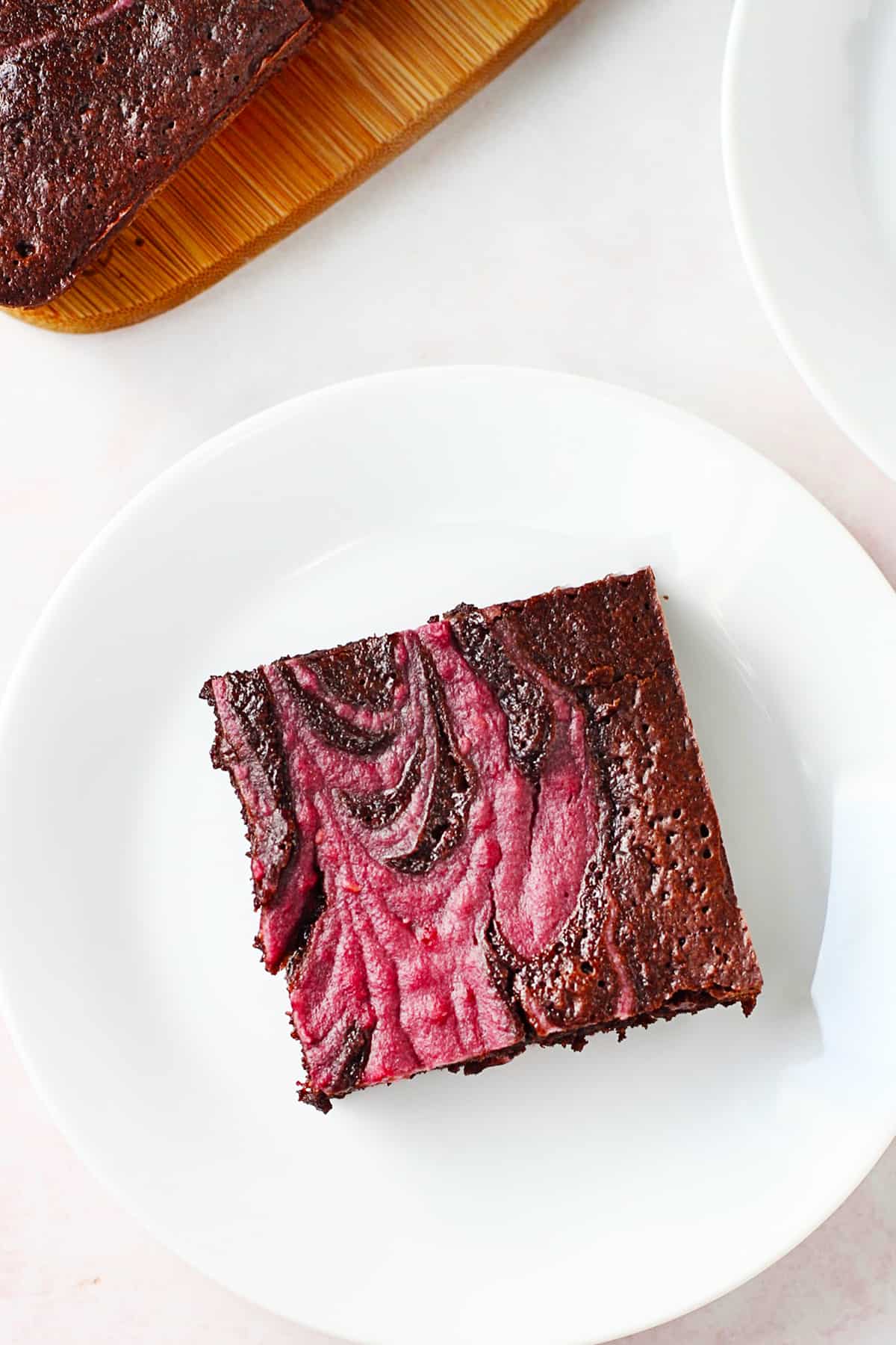 A piece of chocolate raspberry brownies on a plate.