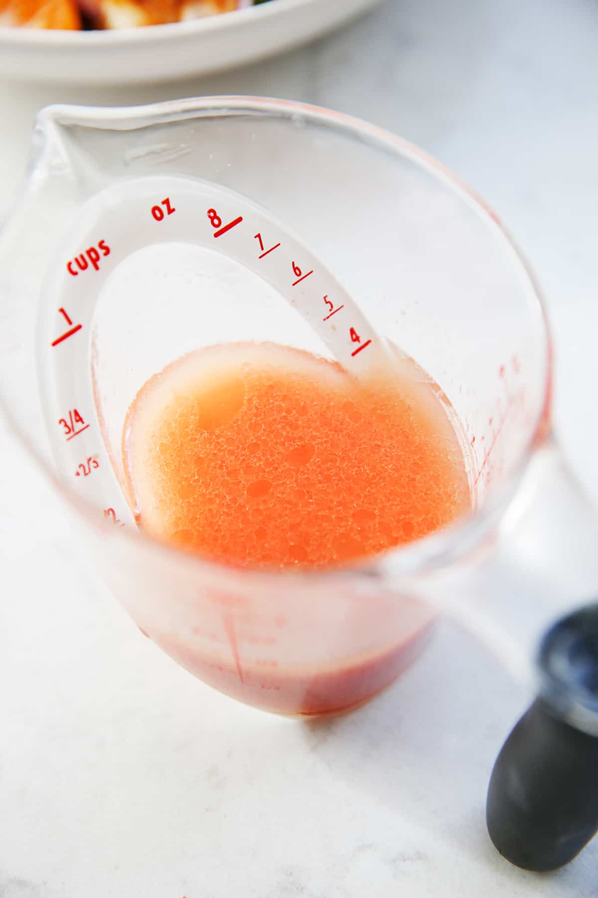 Grapefruit dressing in a measuring cup.