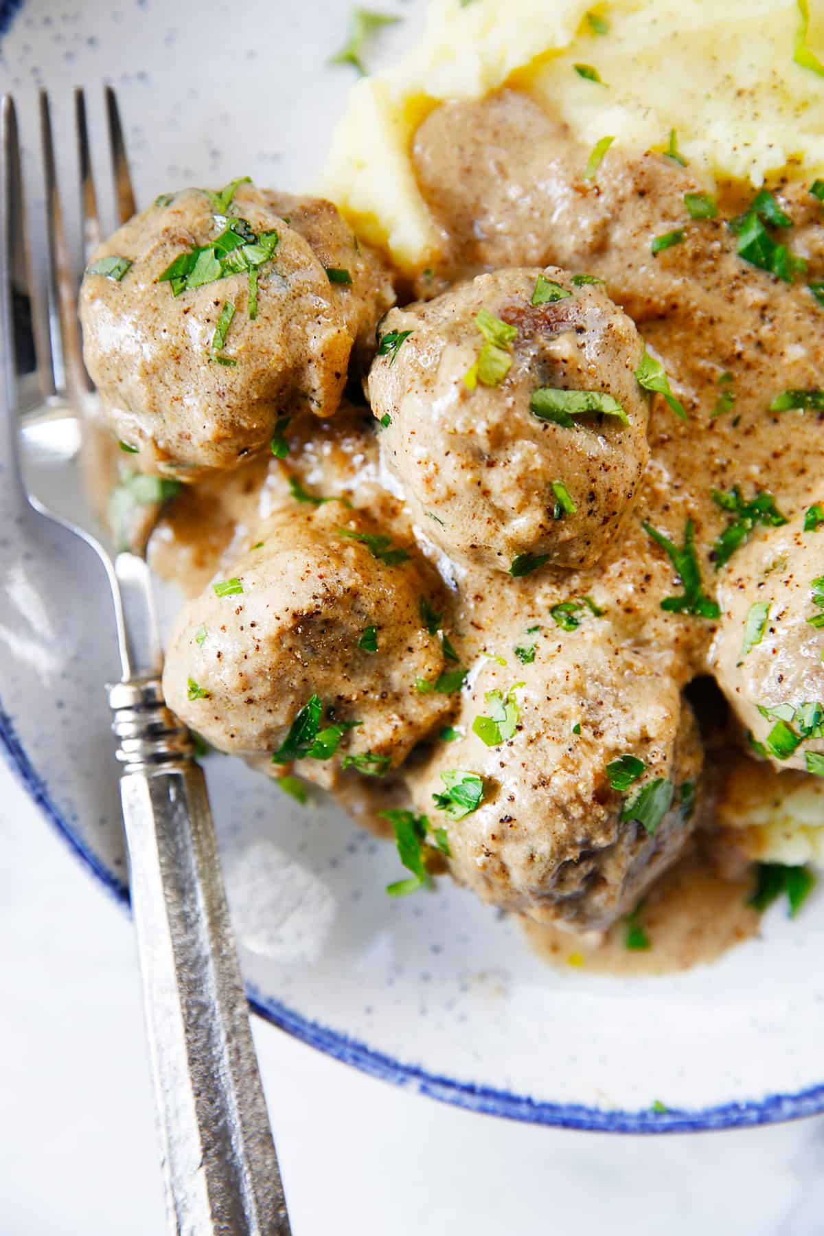 Gluten free Swedish Meatballs smothered in gravy on a plate.