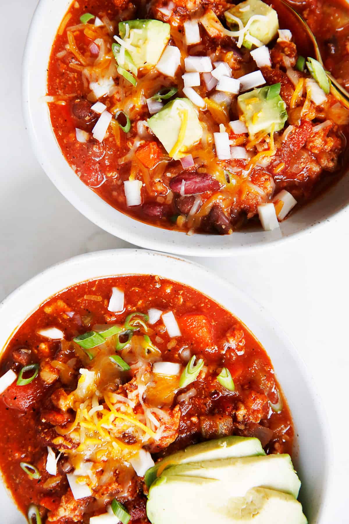 Two servings of ground turkey chili in bowls.