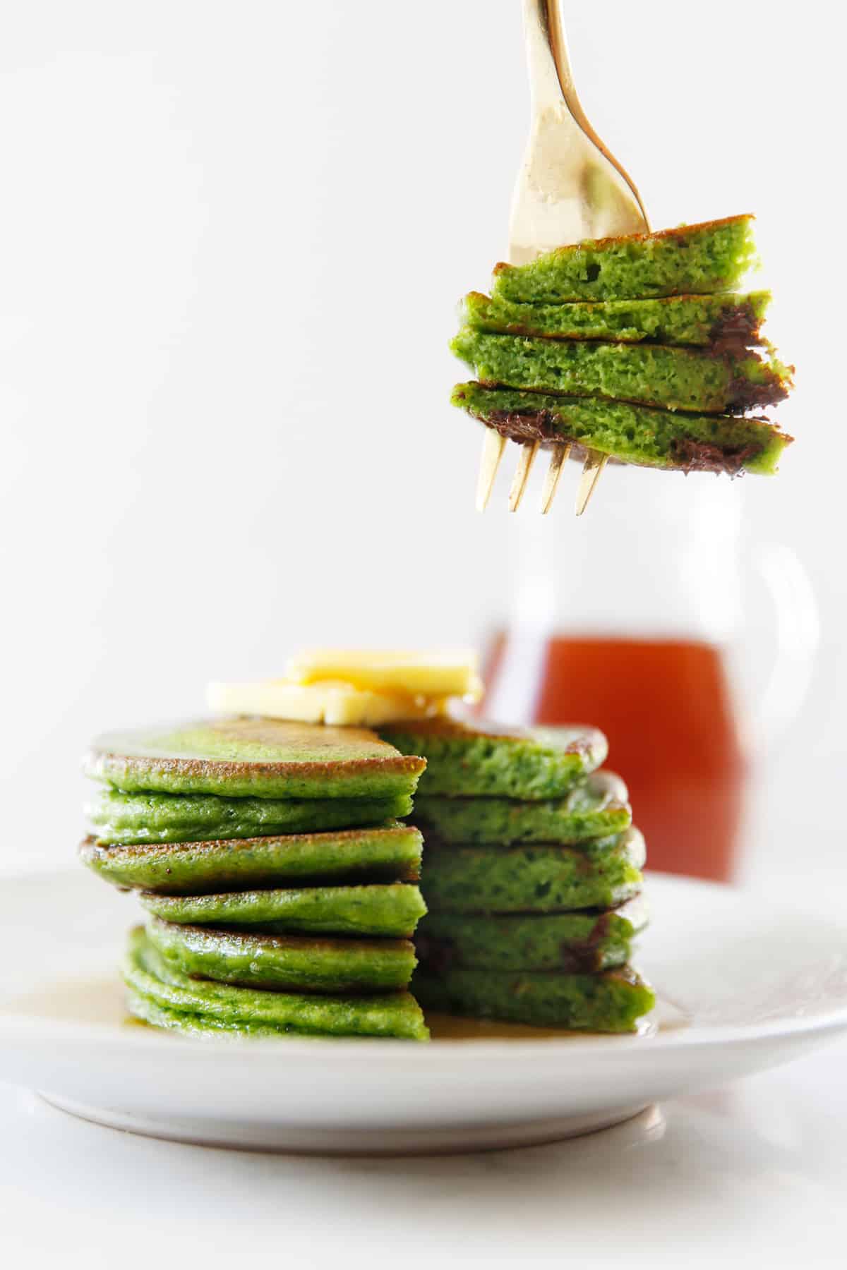 A forkful of spinach pancakes with chocolate chips.