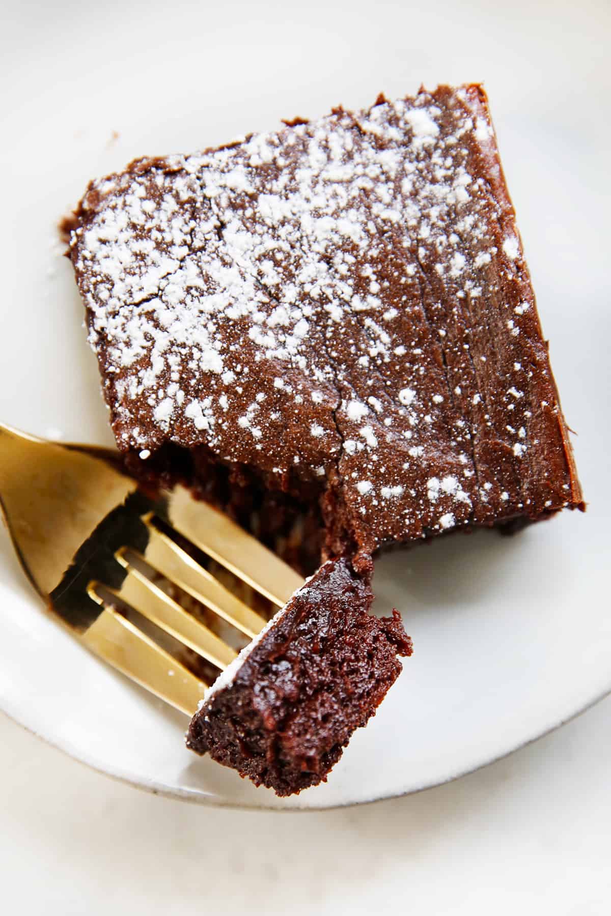 overhead of a forkful being cut off of a brownie on a plate.