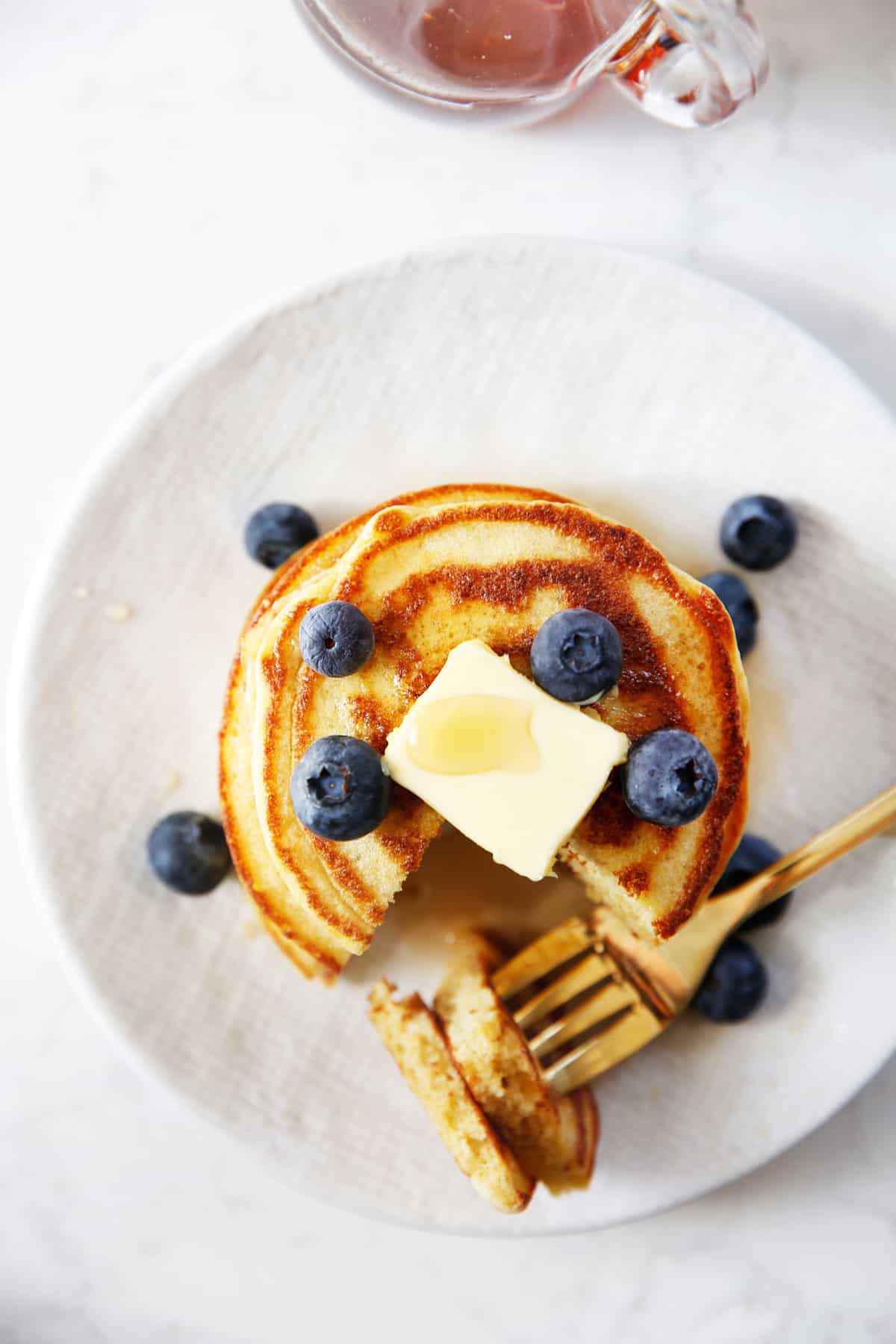 Fluffy paleo pancakes with blueberries on a plate.