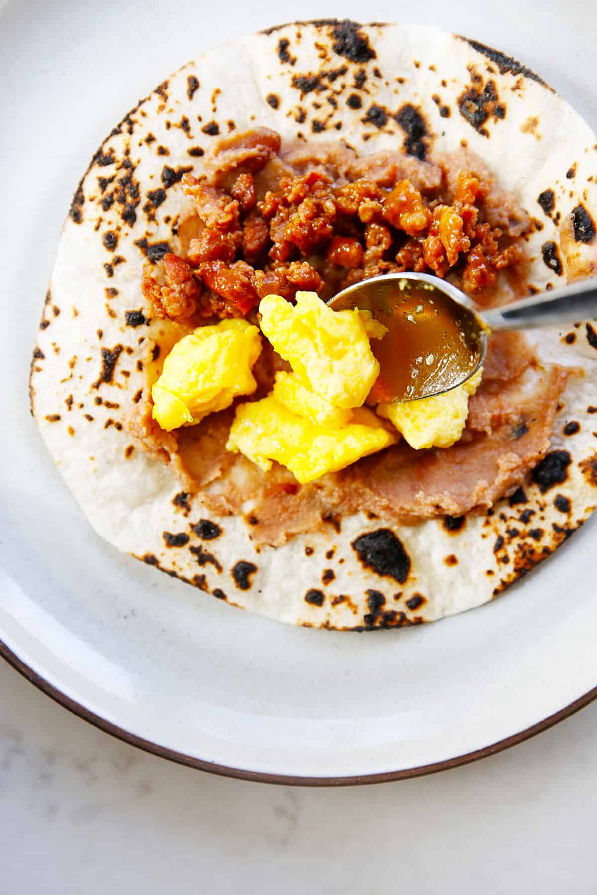 Breakfast tacos with beans, sausage and eggs.