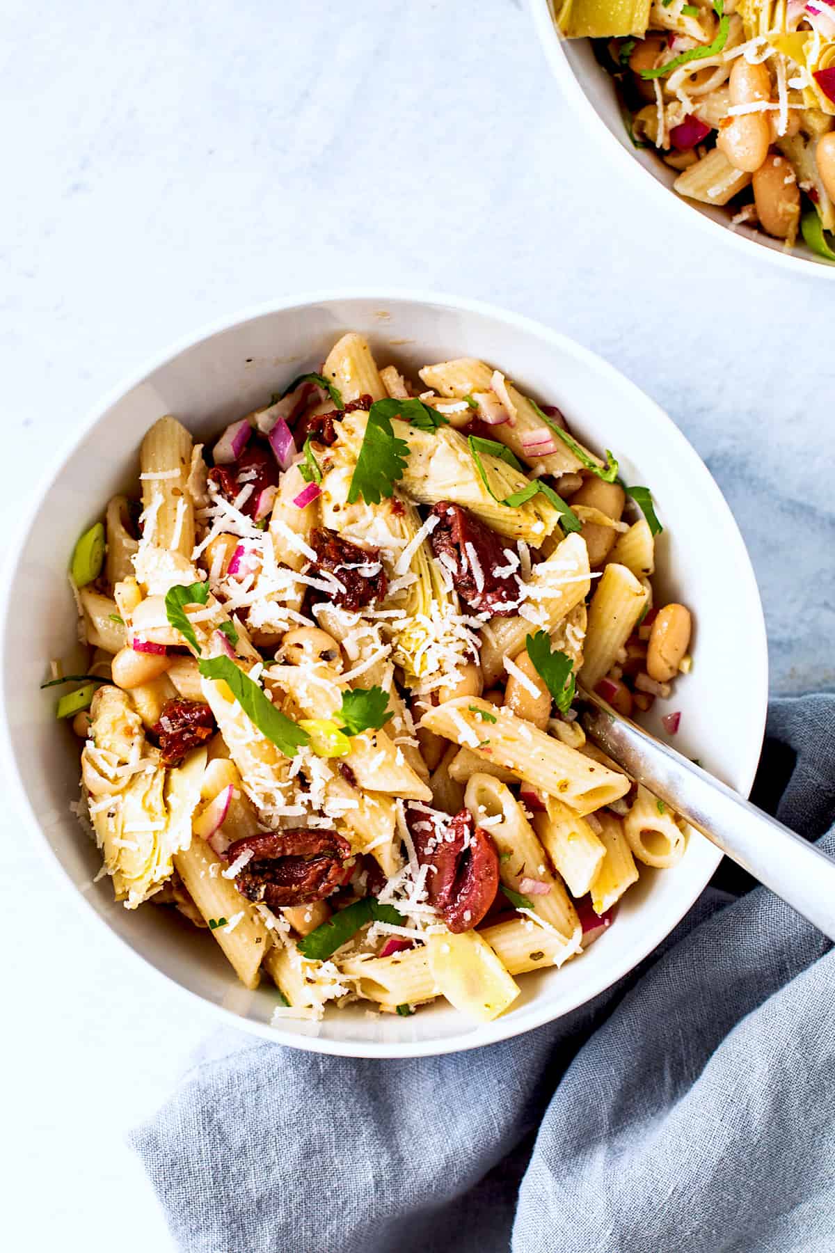 Pasta salad with olives and artichokes in a bowl.