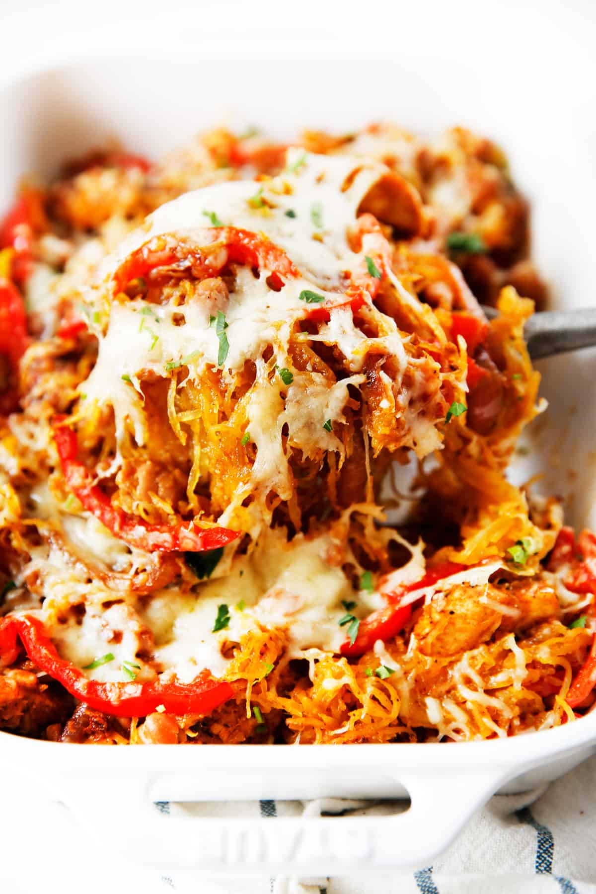 A scoop of Fajita spaghetti squash bake being lifted out of a pan.