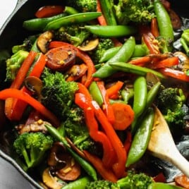 A stir fry of veggies in a cast iron skillet.