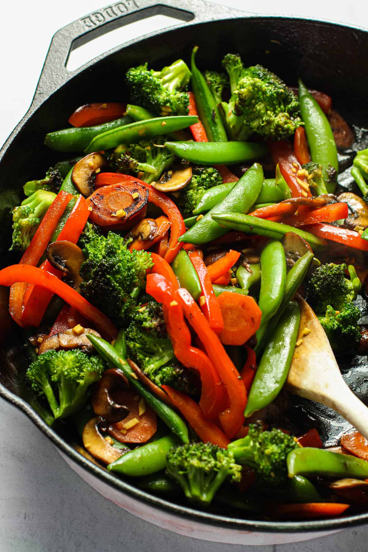 A stir fry of veggies in a cast iron skillet.