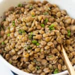Cooked lentils with herbs in a bowl.