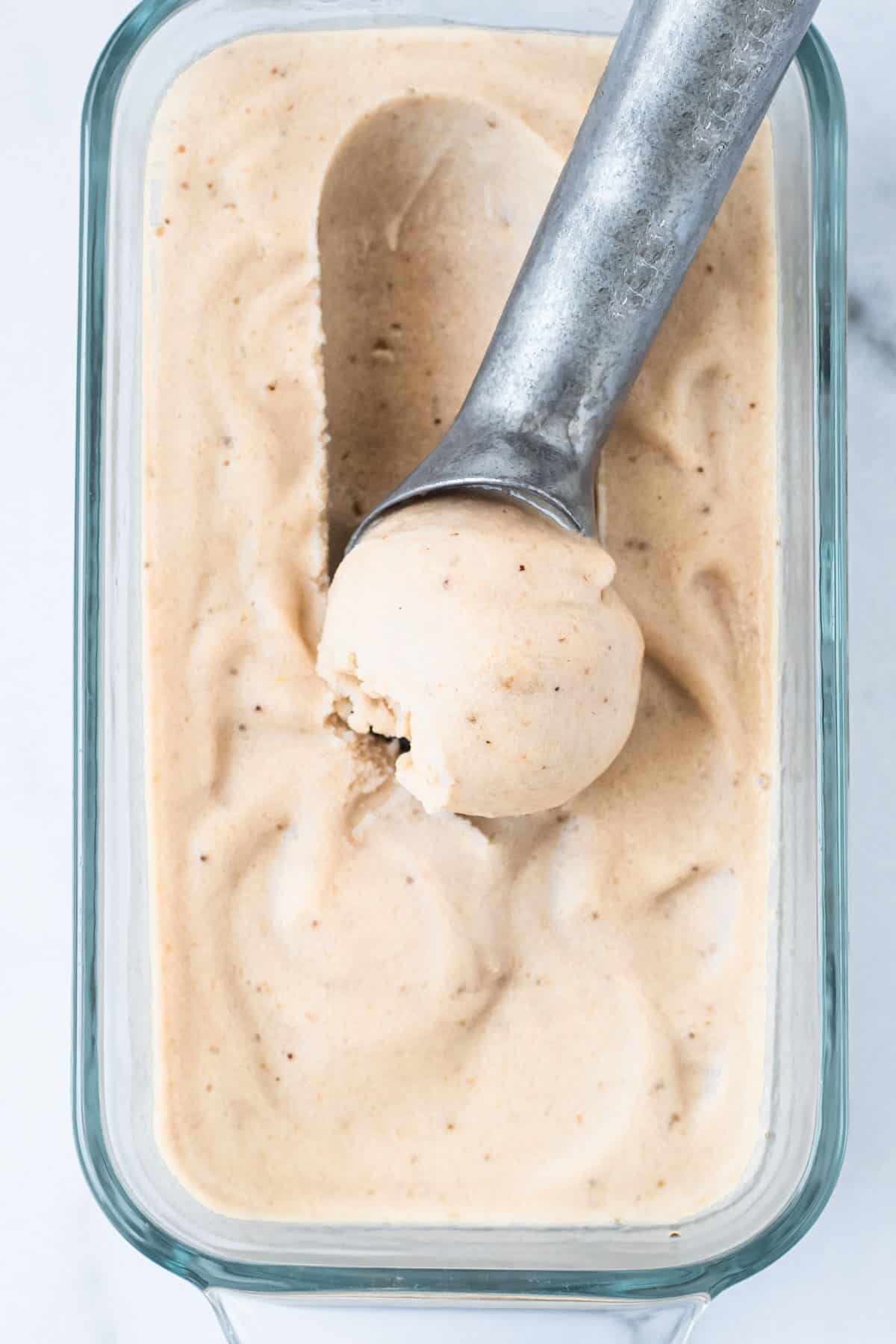 A scoop of banana nice cream in a glass container.
