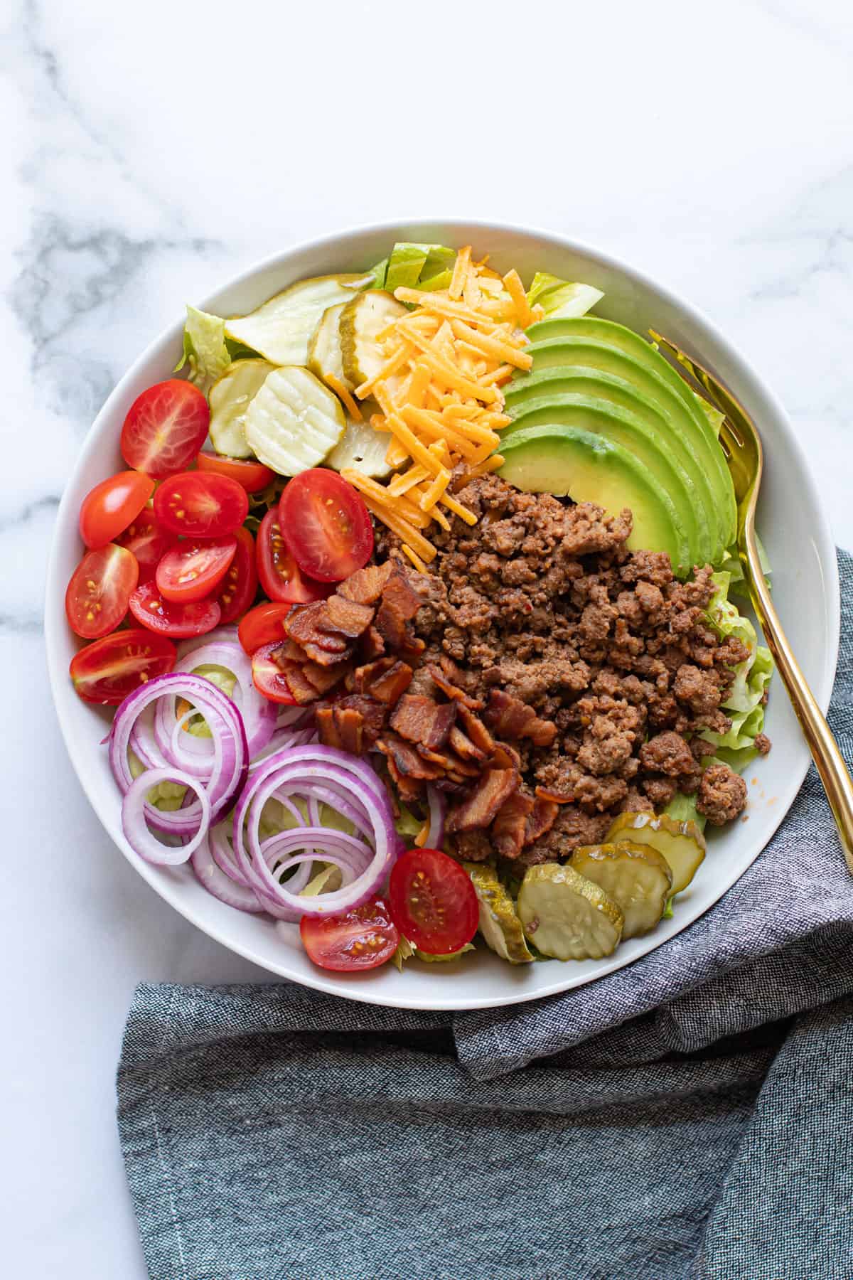 Cheeseburger salad ingredients in a bowl.