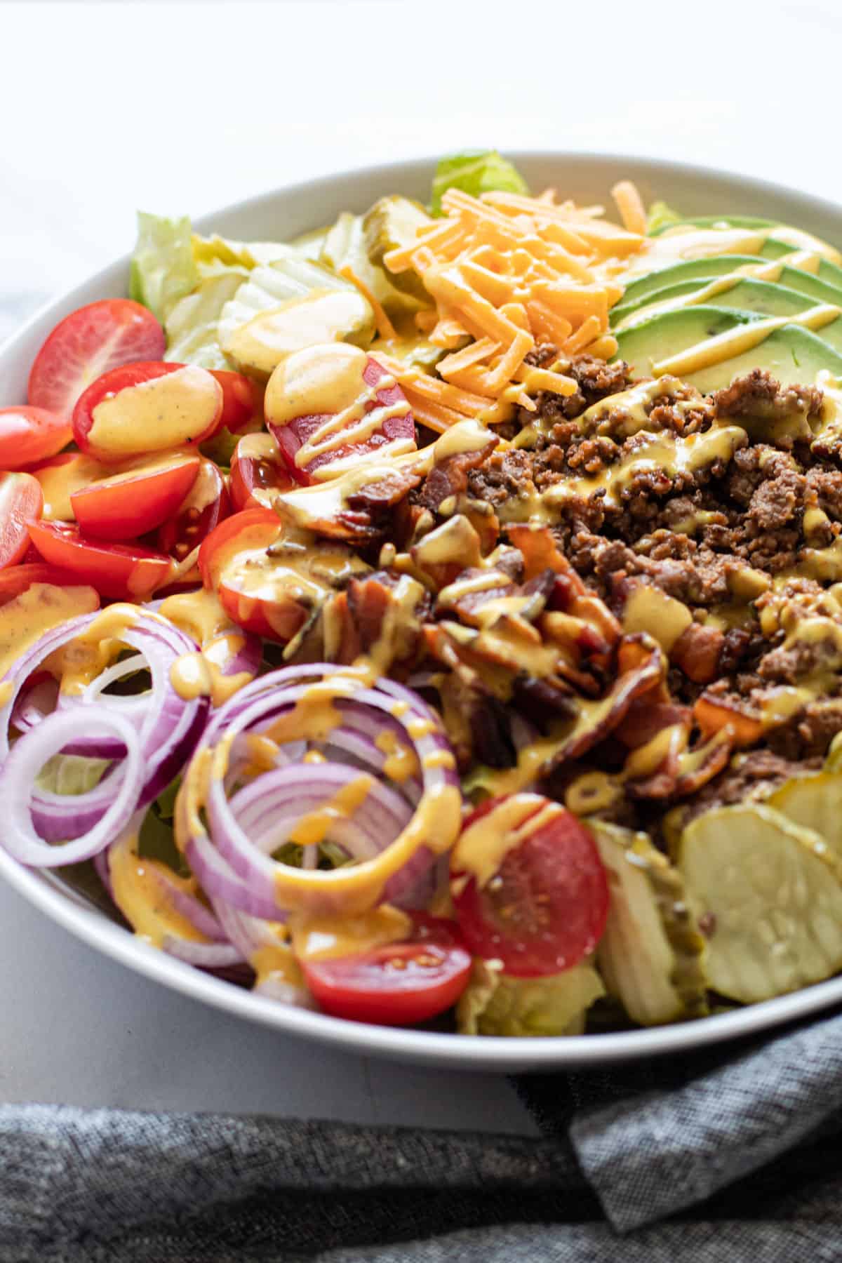 A cheeseburger salad with mustard dressing.