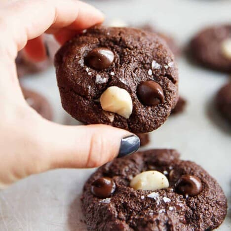 a double chocolate cookie held over another cookie.