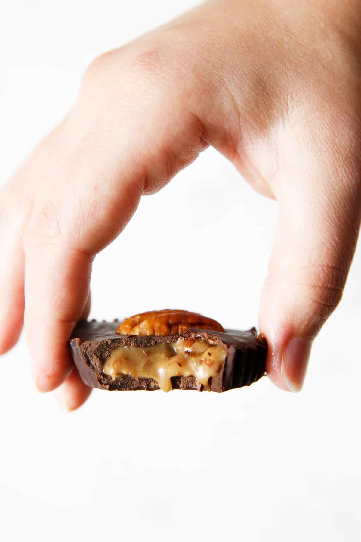 Holding a caramel turtle cup with a bite.