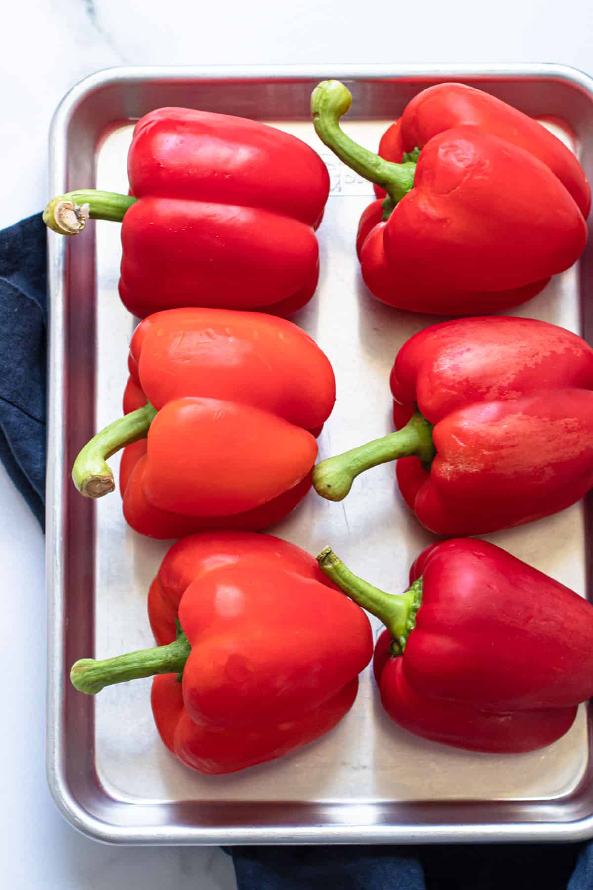 Red peppers on a baking sheet.