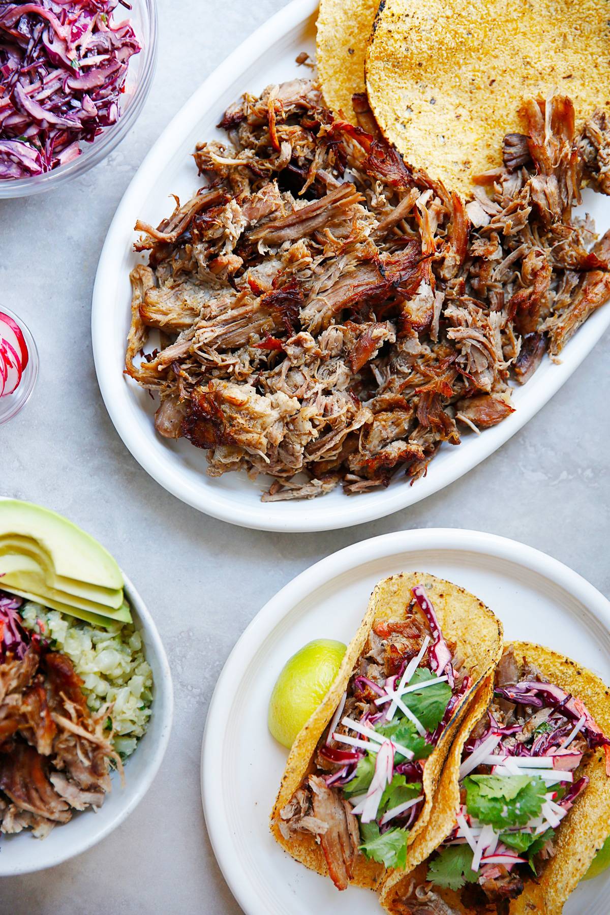 Whole30 pork carnitas with crispy edges on a sheet pan with lime and cilantro