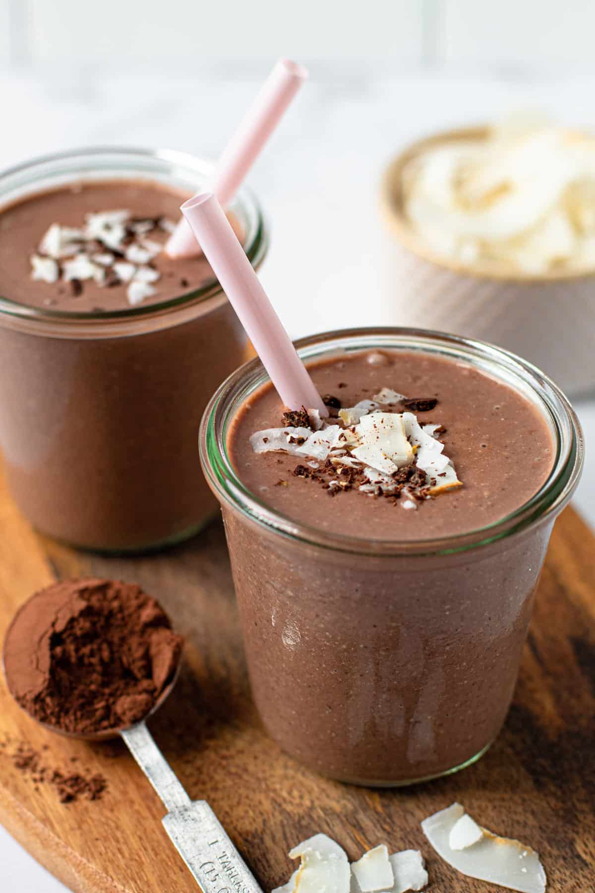 Chocolate coconut smoothie in a glass with shredded coconut on top.
