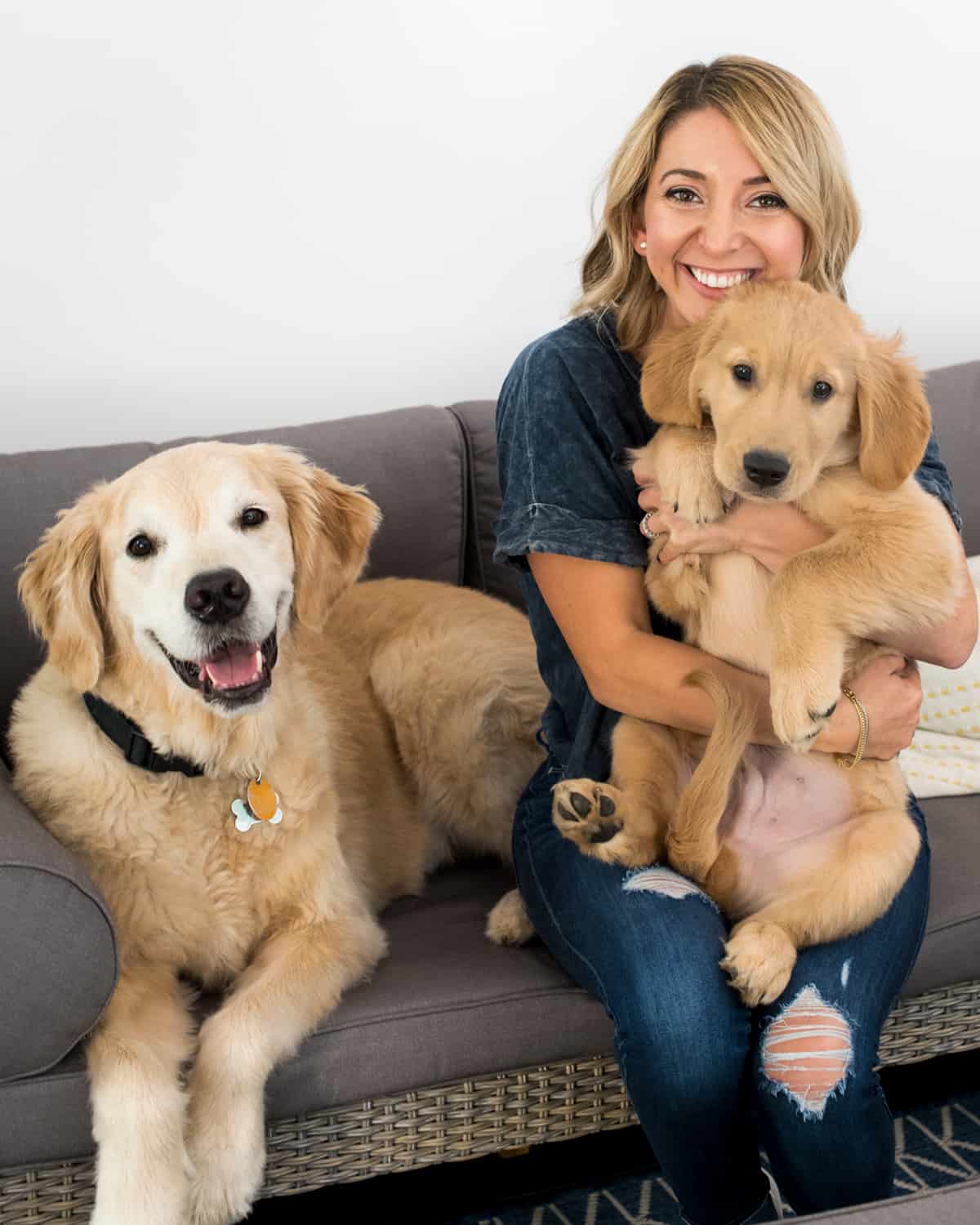 Woman with two dogs on a couch after needing pet insurance.