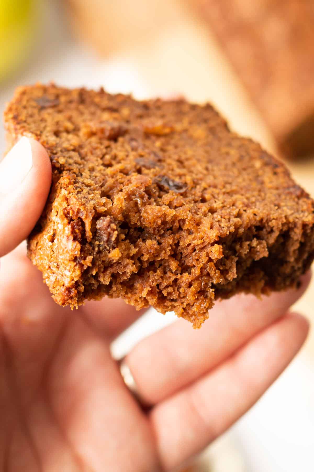 A slice of moist apple bread with a bite taken out of it.
