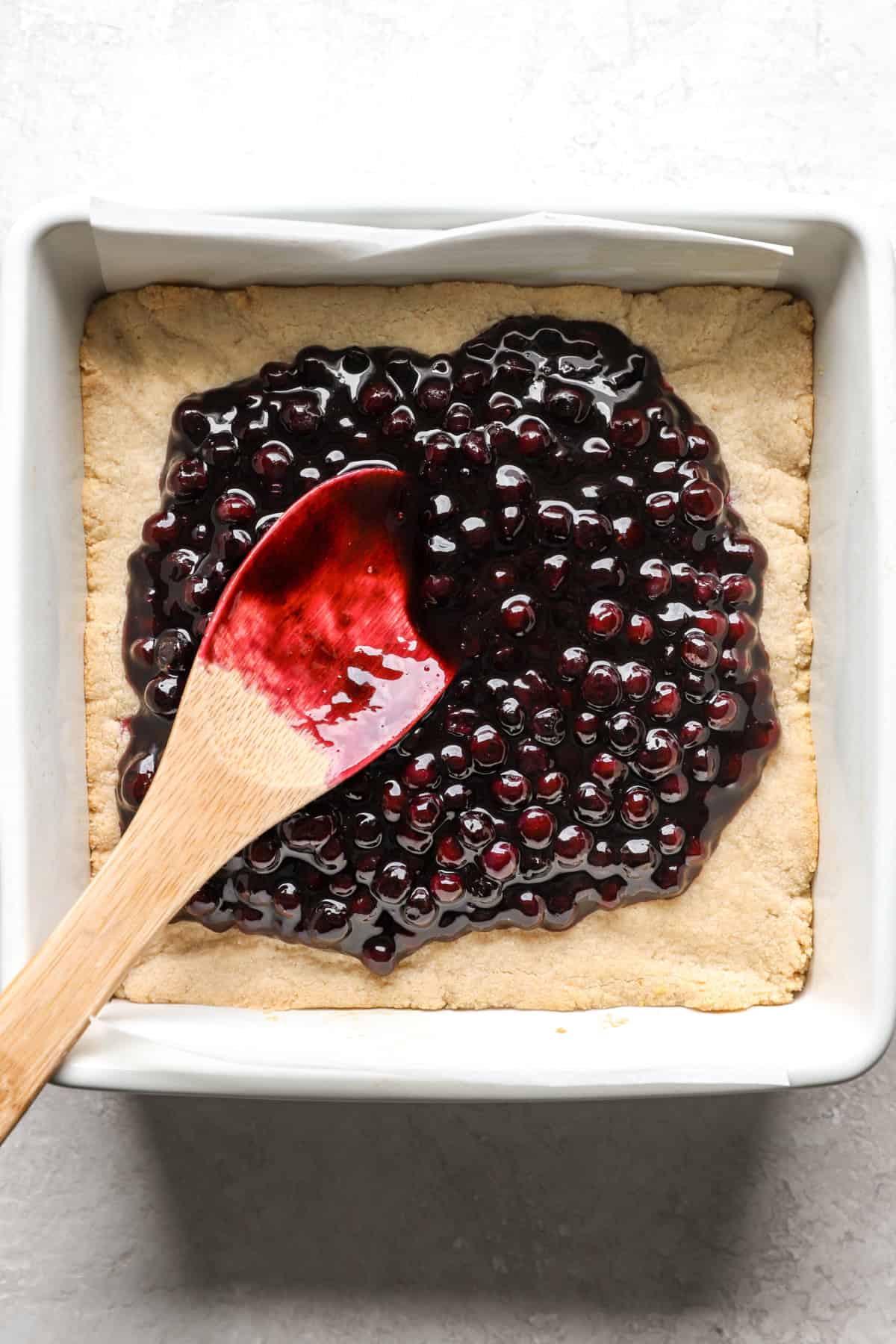 Blueberry filling being spread over crust.