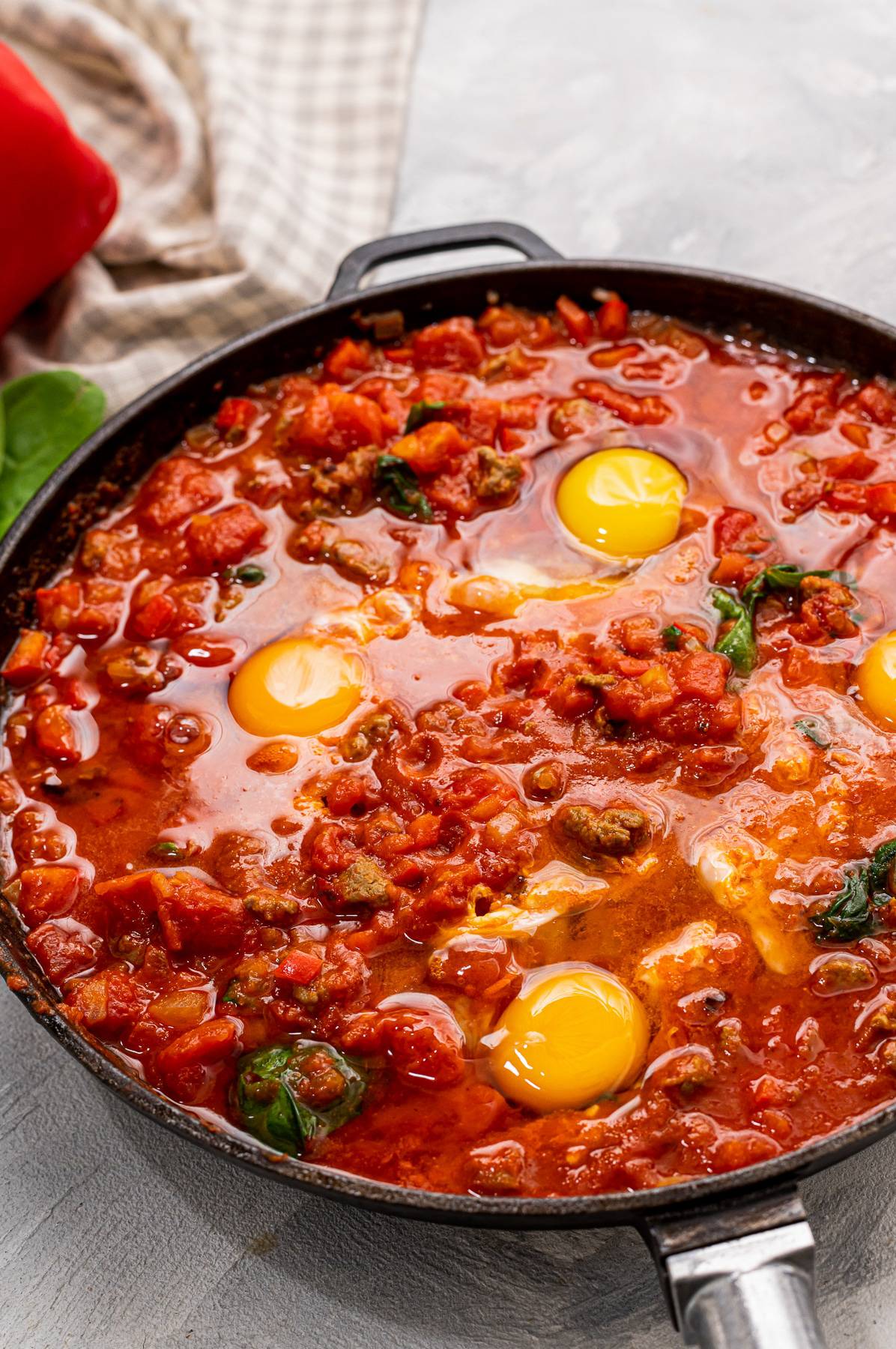 overhead of a skillet with tomato sauce and egg.