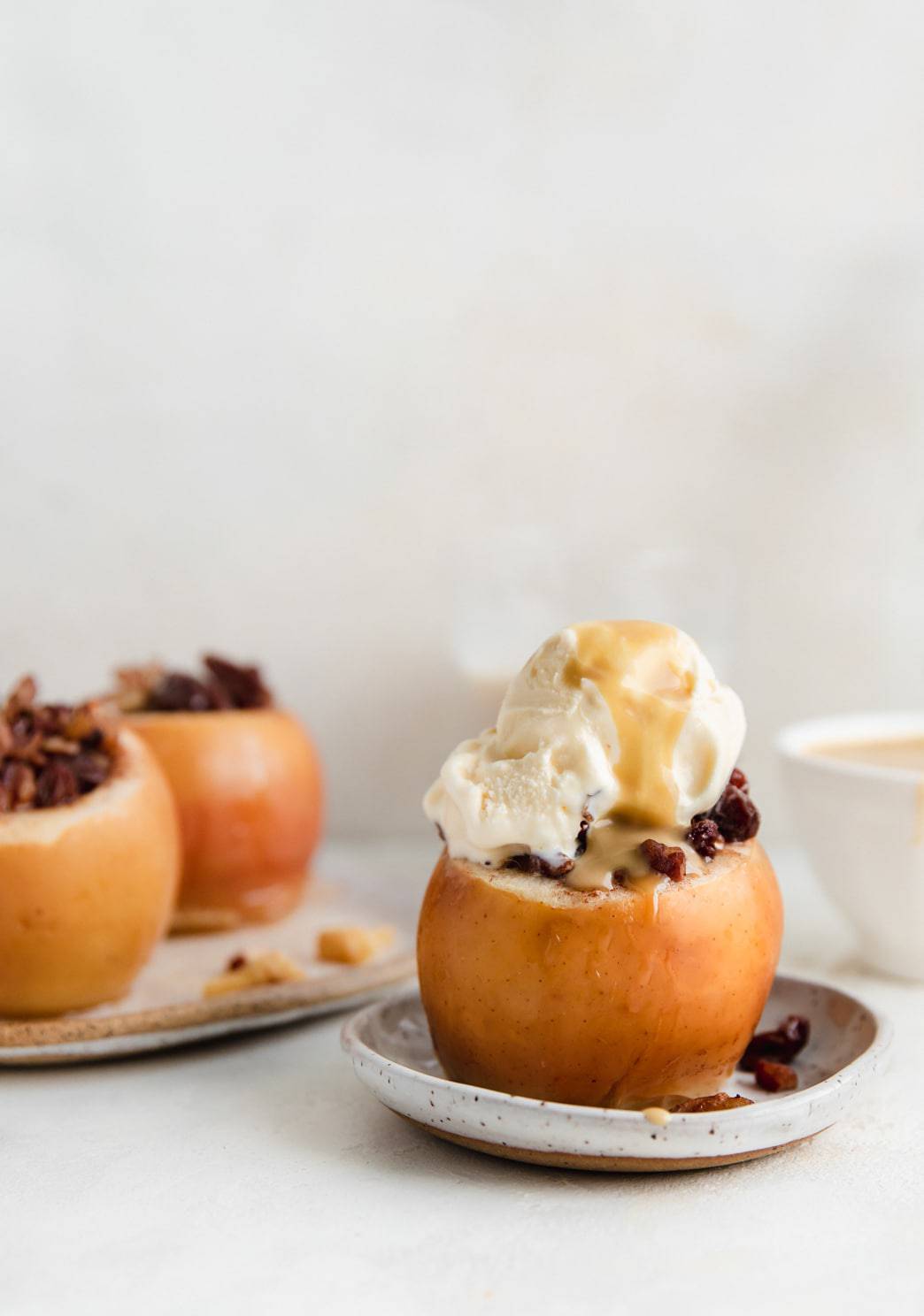 Slow cooker baked apples on a plate with toppings.
