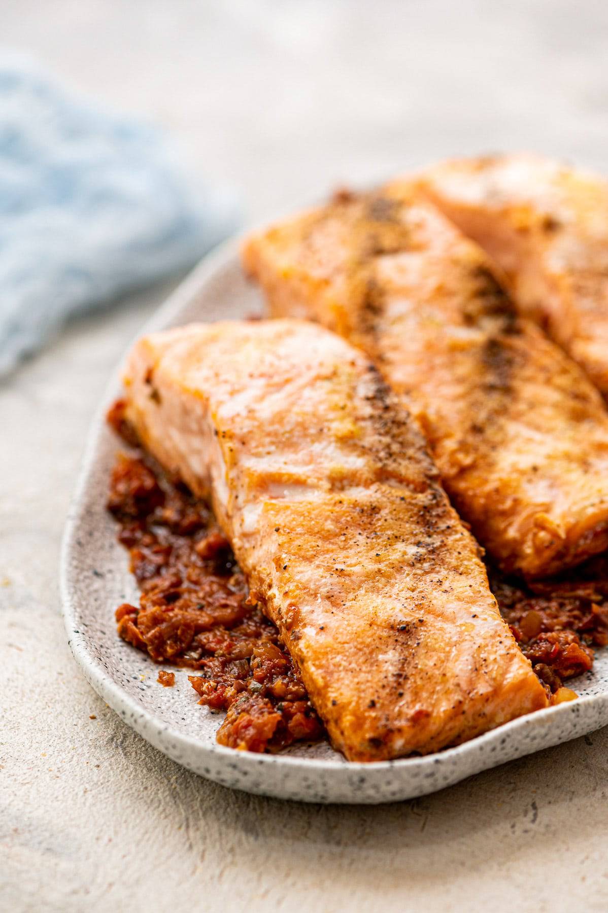 Salmon puttanesca on a plate.