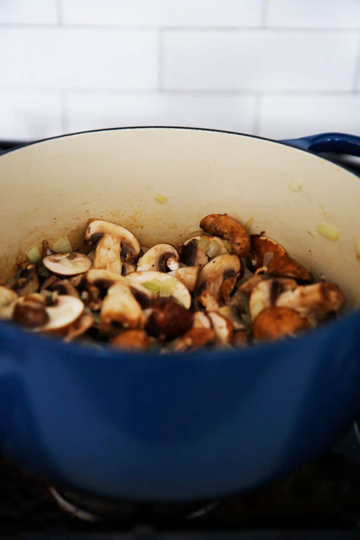 Mushrooms and aromatic herbs and vegetables cooking down for soup