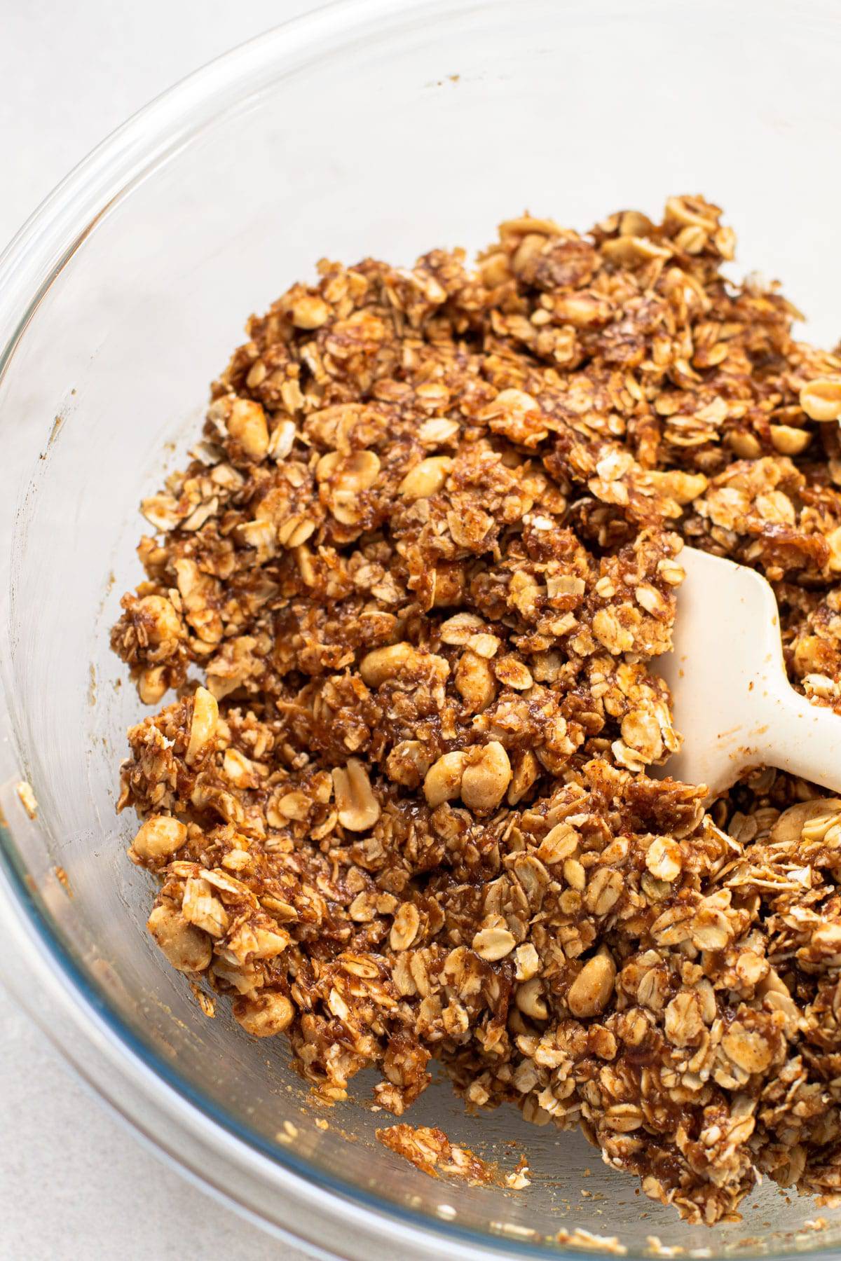 Ingredients for pb + j granola mixed together in a bowl.