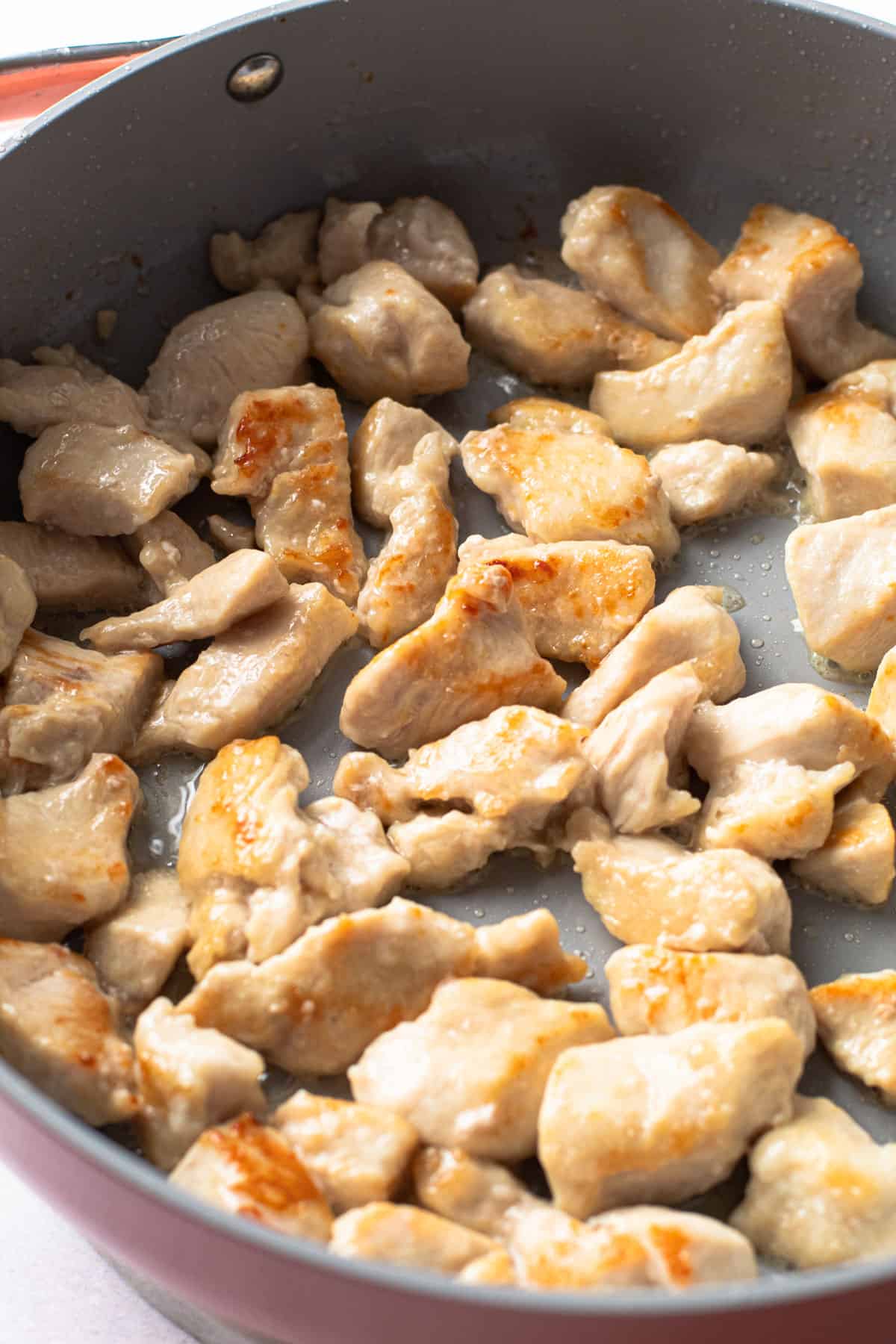 Chicken browning in a skillet.