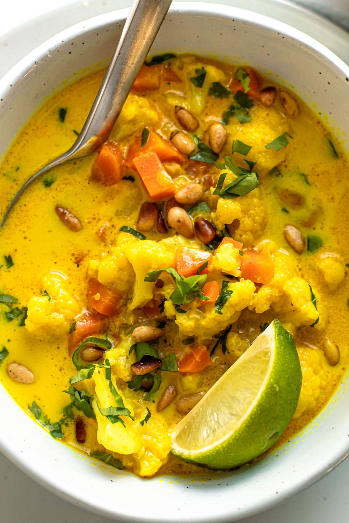 Vegan cauliflower soup in a bowl with coconut milk and ginger.