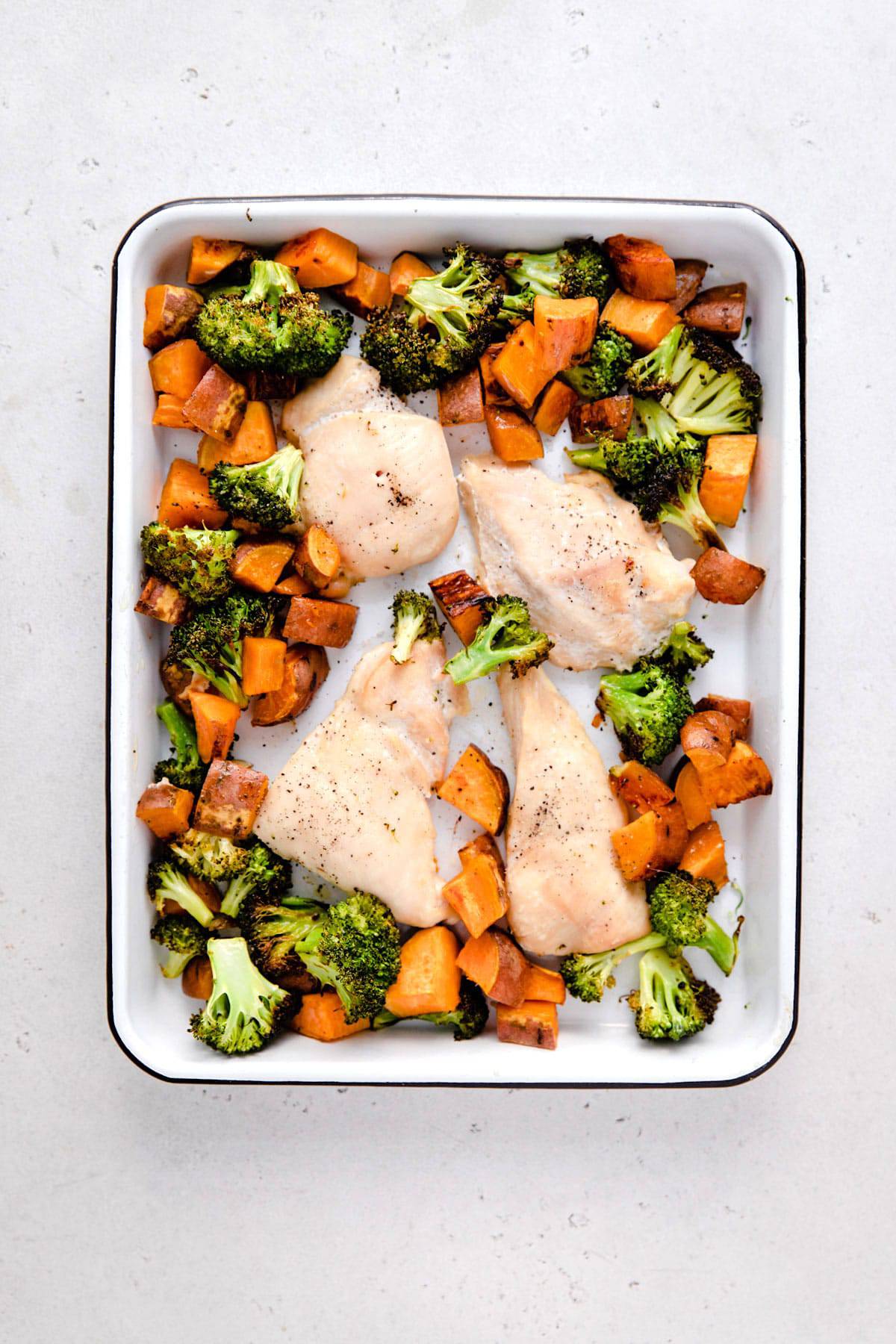 A sheet pan with chicken and roasted vegetables.