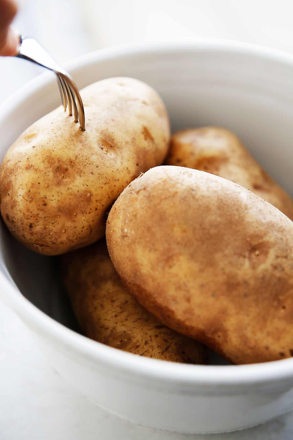 Poking a hole in russet potatoes.