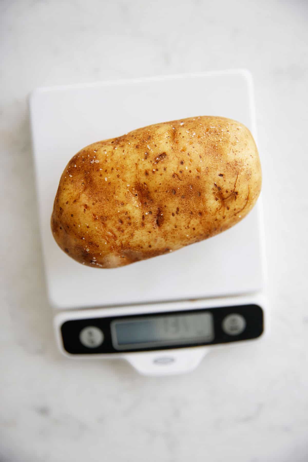 A potato on a scale to measure the size.