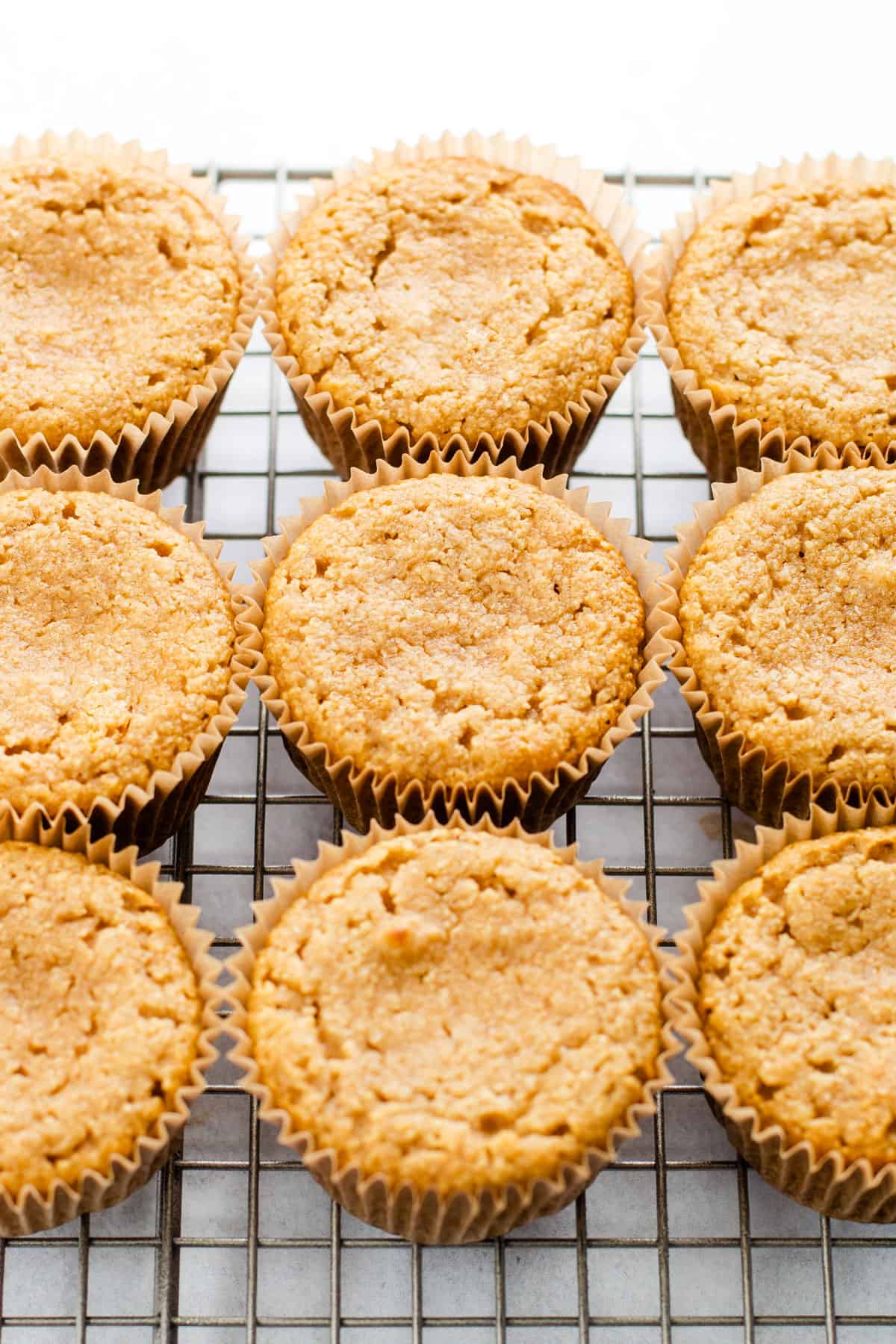 Gluten-free vanilla cupcakes cooling on a rack.