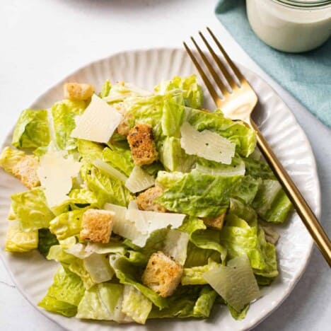 A classic Caesar salad on a plate with a fork.