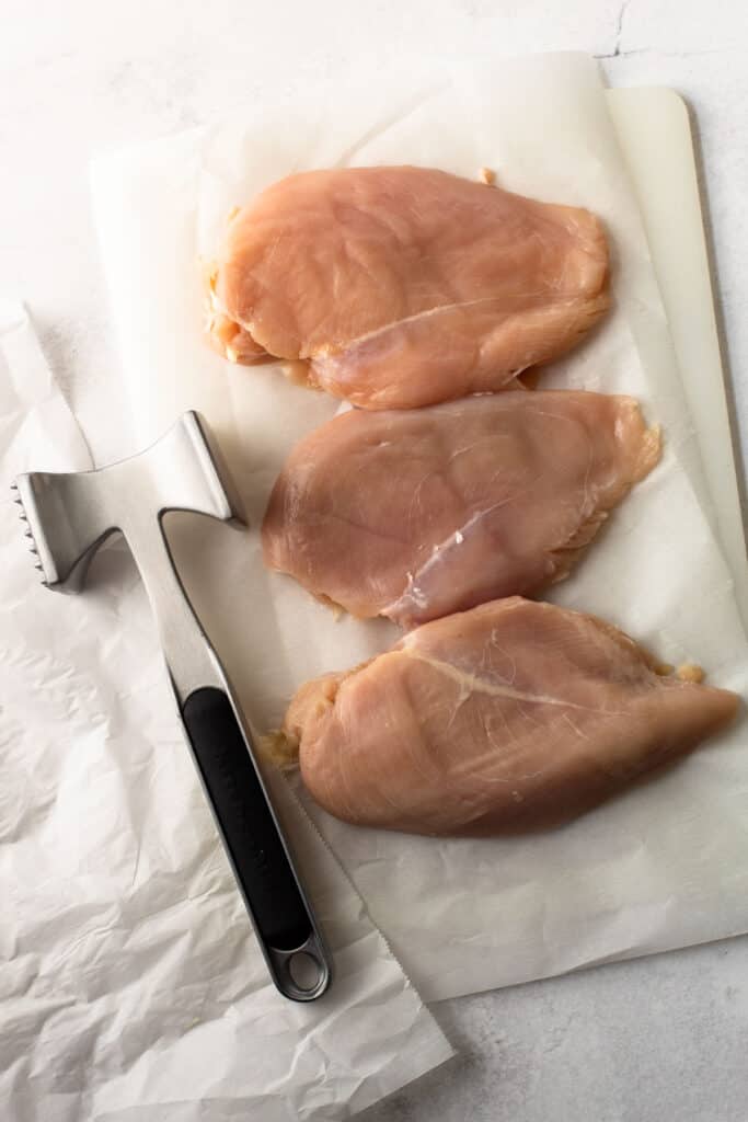 Chicken on a cutting board being pounded out