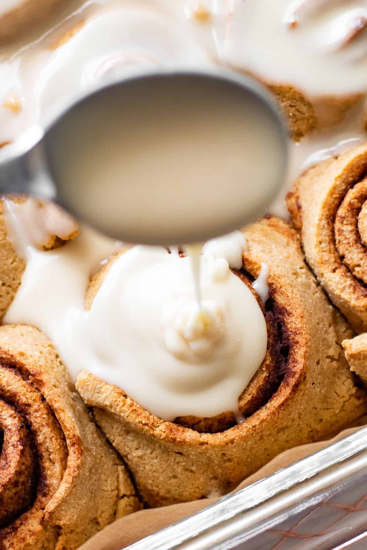 Drizzling glaze on cinnamon rolls.