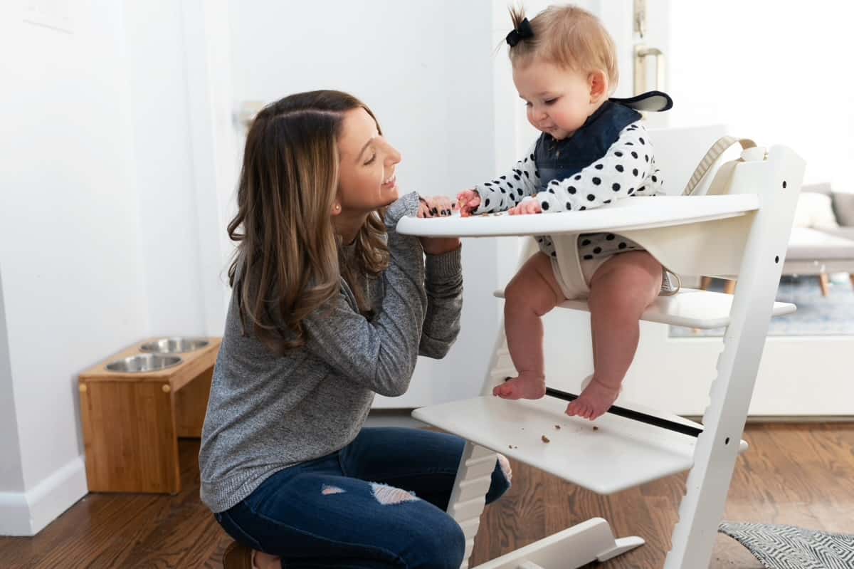 Baby and mom at high chair starting solid food