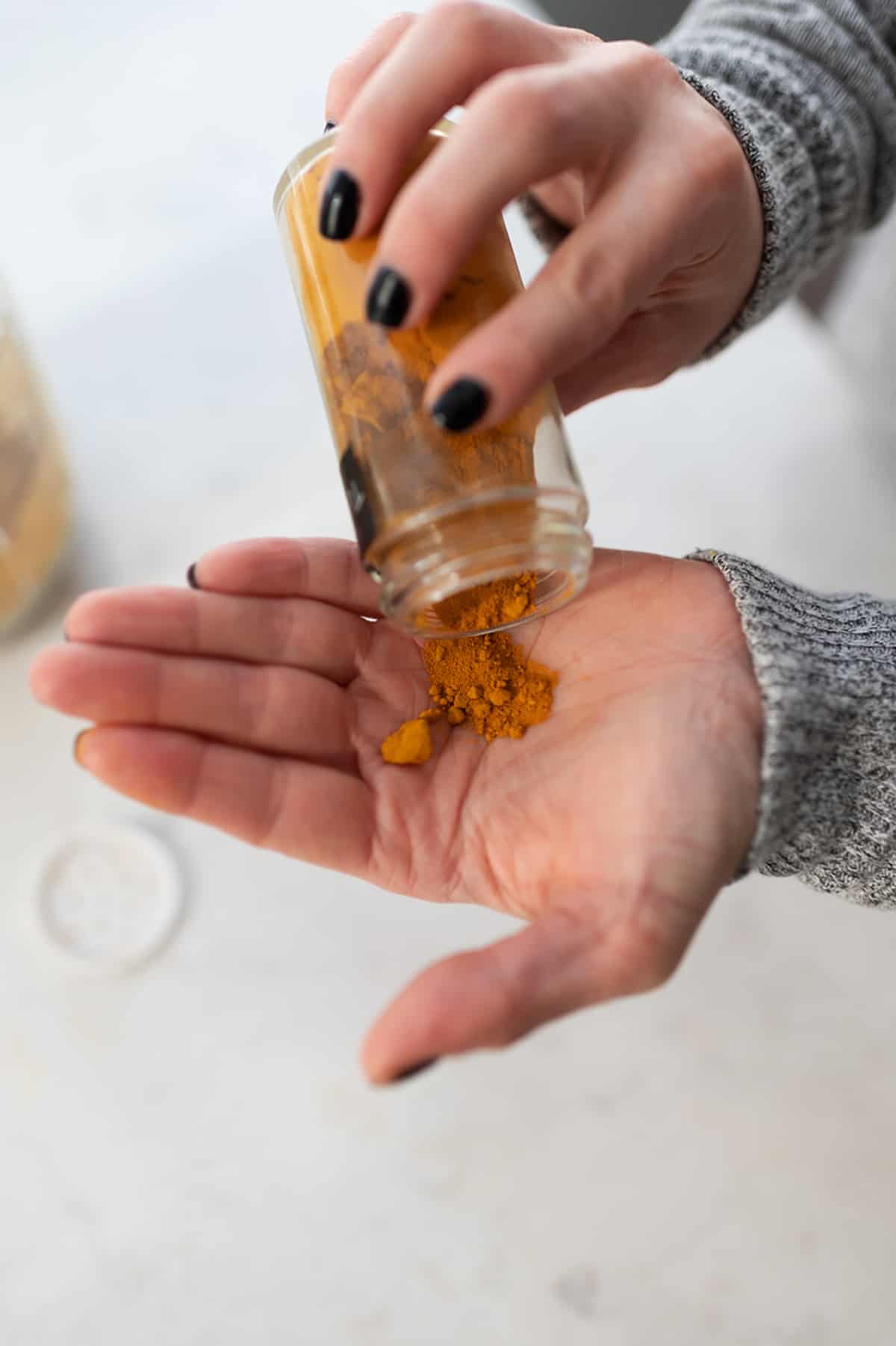 Ground spices being poured into a hand.