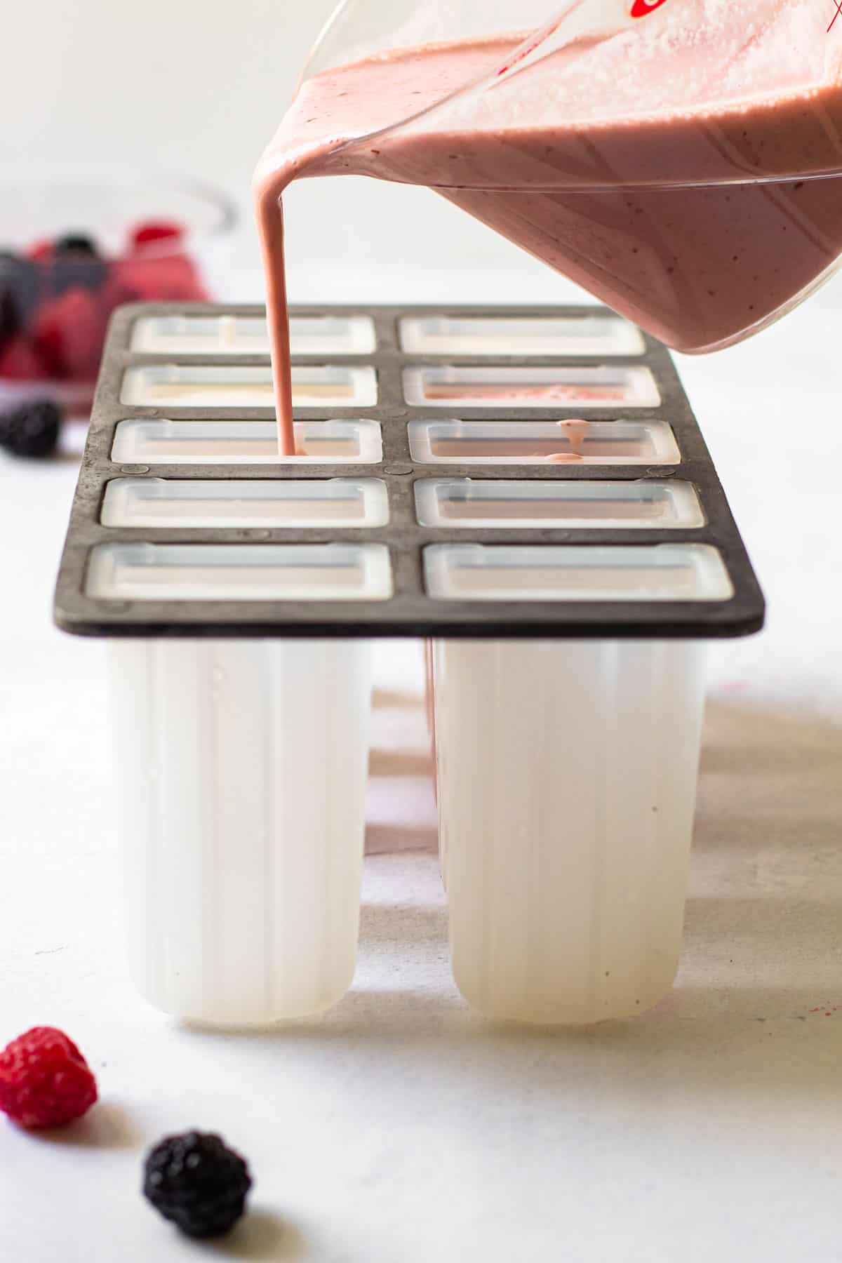Pouring greek yogurt popsicles into molds.