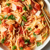 Fresh tomato pasta in a bowl with basil.