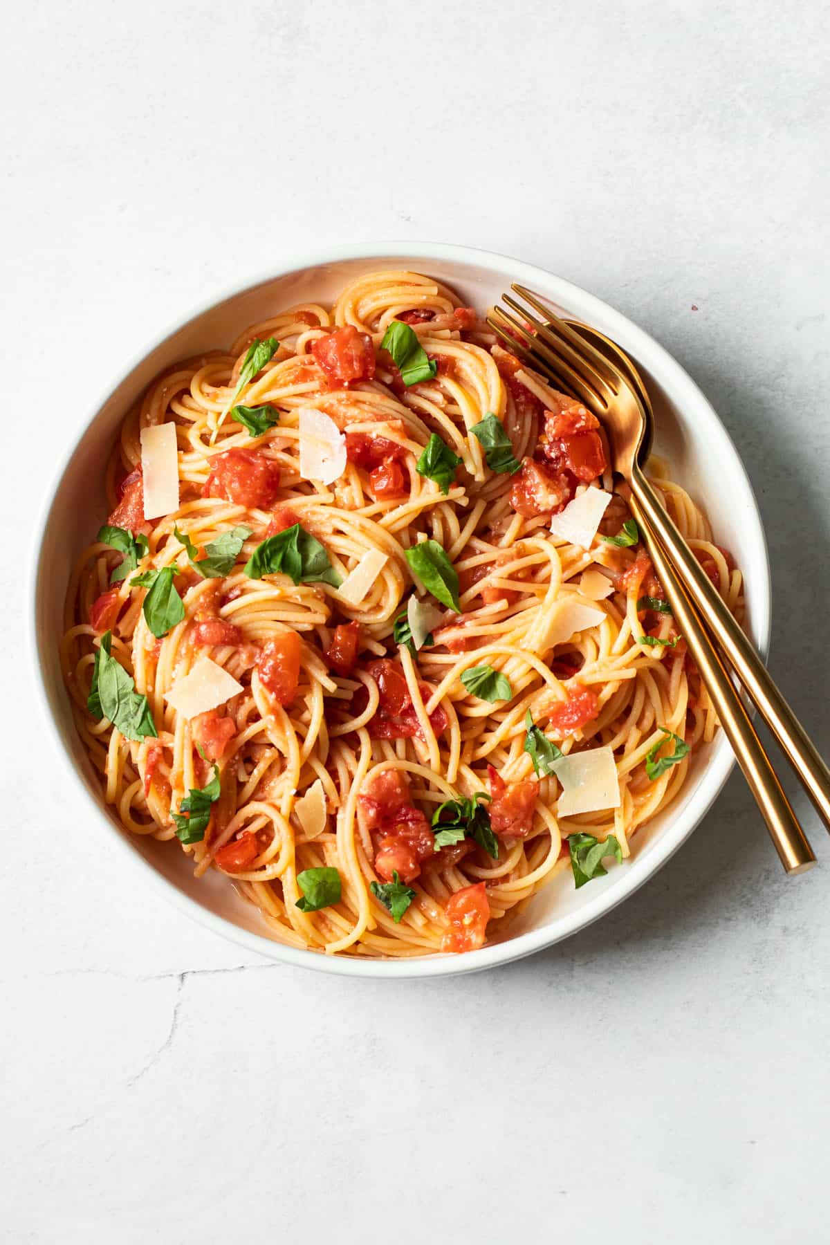 A bowl of fresh tomato pasta with basil.