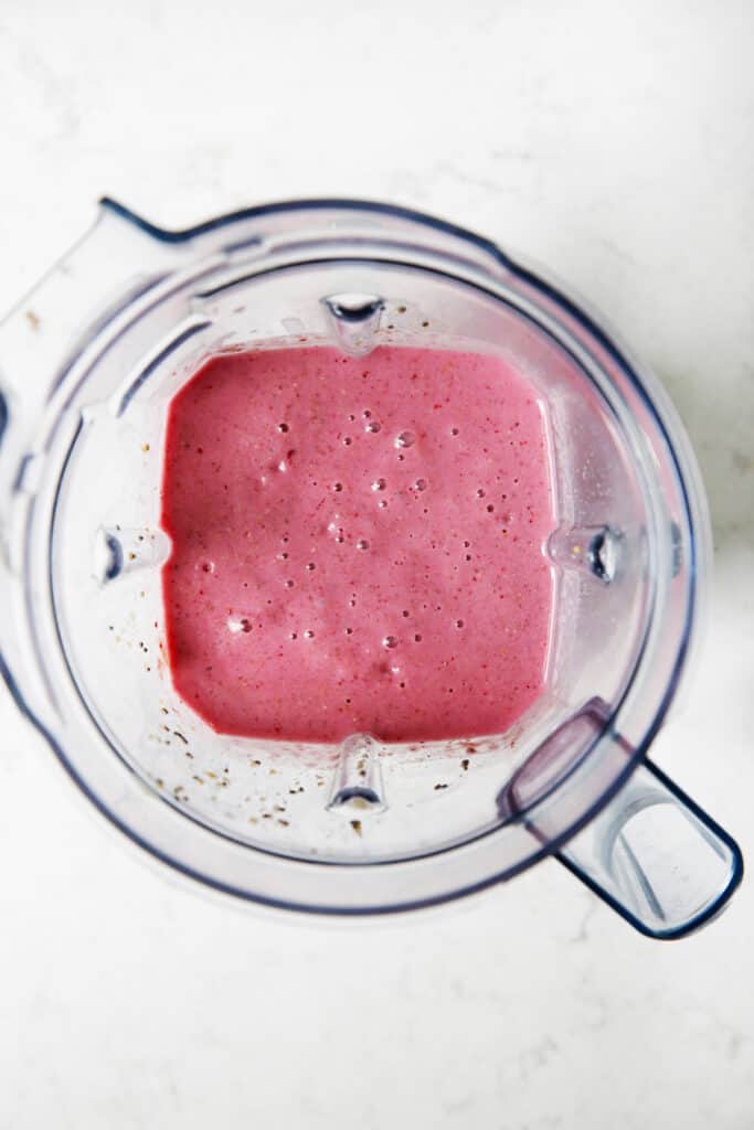 A blended peanut butter and jelly smoothie in blender.