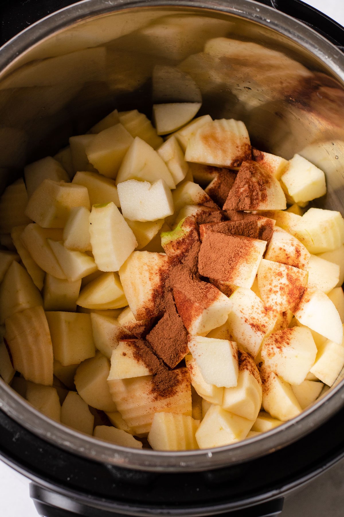 Apples inside of an instant pot with cinnamon.
